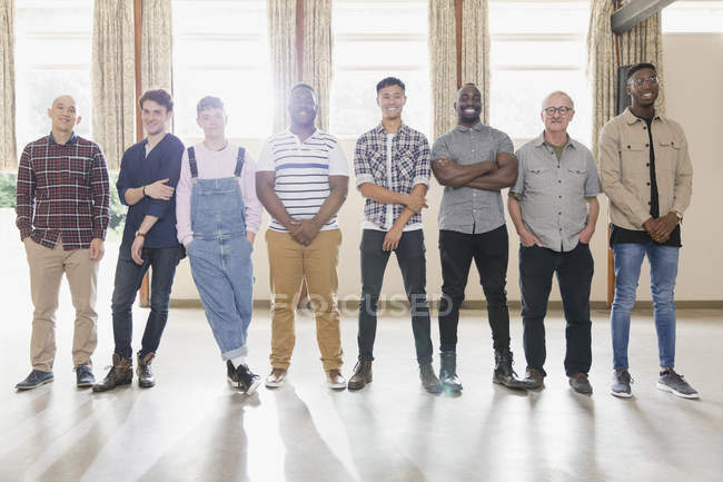 Portrait confident men standing in a row in community center — Stock Photo