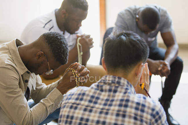 Männer beten mit Rosenkränzen in Gebetsgruppe — Stockfoto