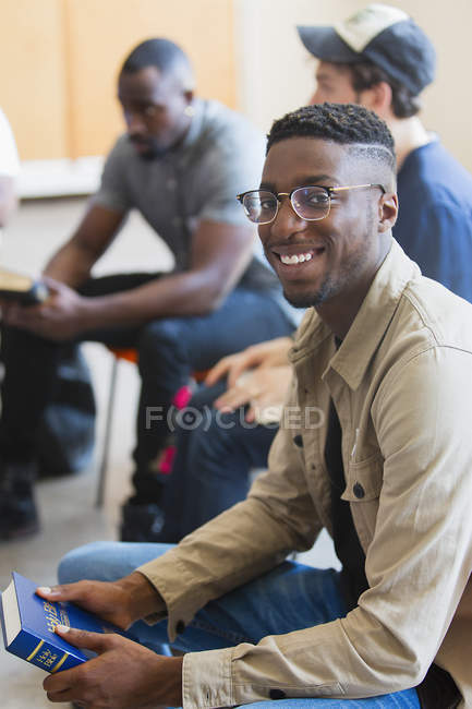 Portrait smiling man holding bible in prayer group — Stock Photo