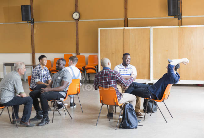 Hombres hablando en terapia de grupo en el centro comunitario - foto de stock