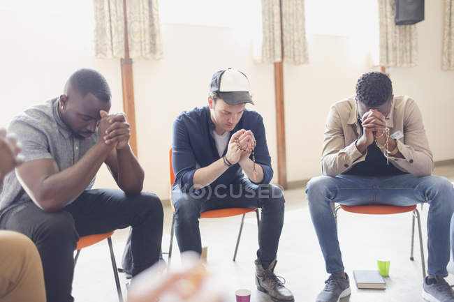 Männer beten mit Rosenkränzen in Gebetsgruppe — Stockfoto