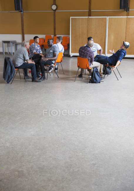 Hommes parlant en thérapie de groupe dans un centre communautaire — Photo de stock
