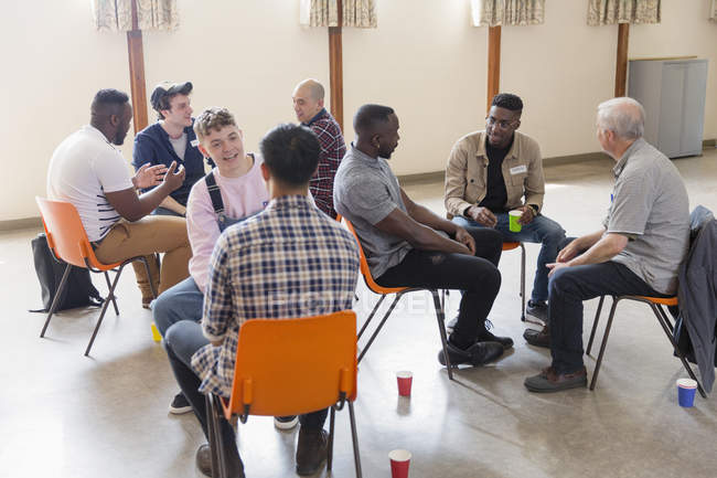 Hommes parlant en thérapie de groupe dans un centre communautaire — Photo de stock