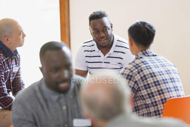 Men talking and listening in group therapy — Stock Photo