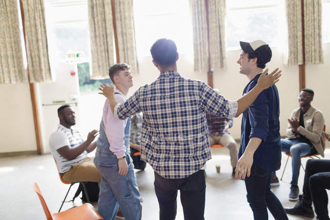 Men talking and clapping in group therapy in community center — Stock Photo