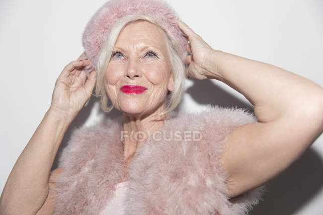 Уверенная в себе, гламурная пожилая женщина в розовом мехе — стоковое фото