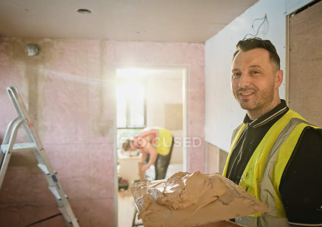 Portrait confident construction worker plastering — Stock Photo