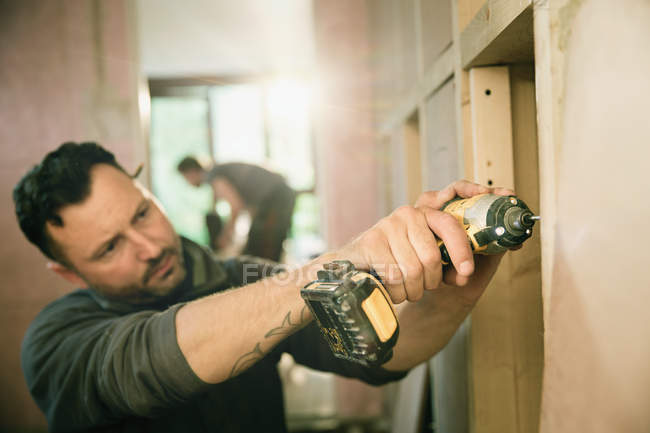 Focused construction worker using power drill — Stock Photo