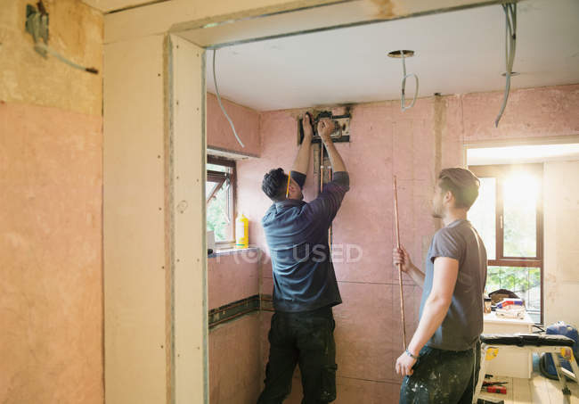 Construction workers installing copper pipe in house — Stock Photo