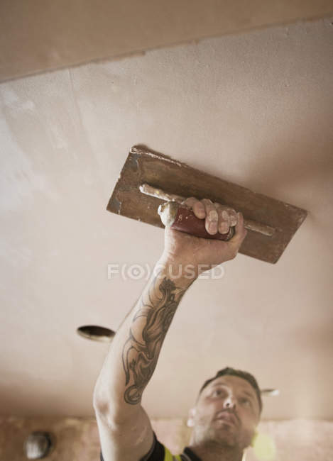 Operaio edile con soffitto intonaco tatuaggio — Foto stock