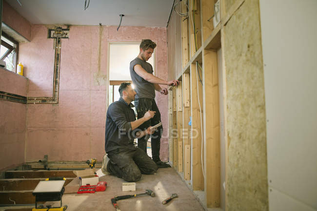 Trabalhadores da construção civil enquadrando dentro de casa — Fotografia de Stock