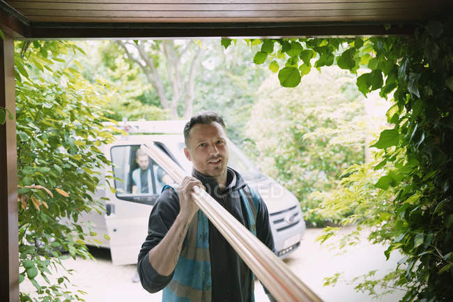 Portrait confident carpenter carrying equipment in garage — Stock Photo