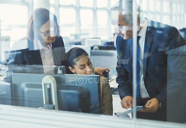 Gente de negocios discutiendo papeleo en la computadora en la oficina - foto de stock
