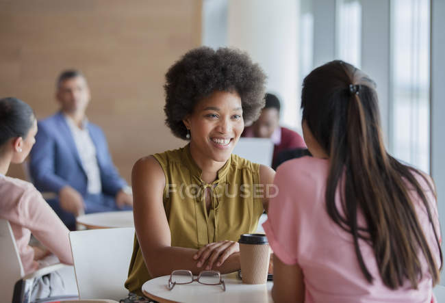 Smiling businesswomen enjoying coffee break — Stock Photo