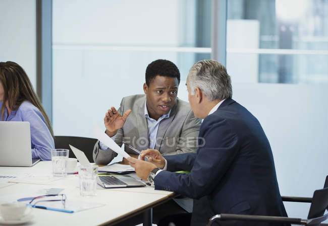Бизнесмены обсуждают бумажную работу в конференц-зале — стоковое фото