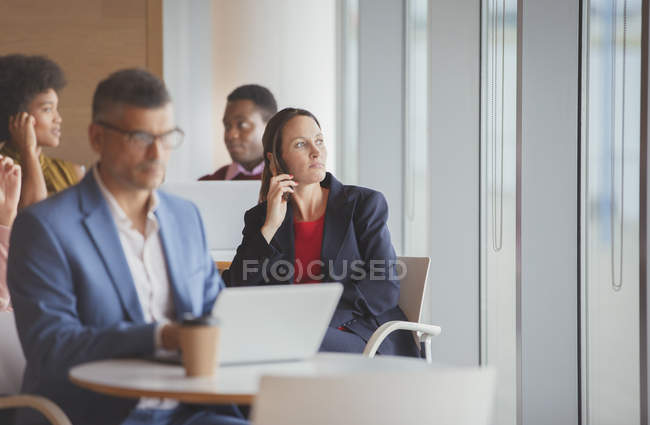 Thoughtful businesswoman looking out window in cafeteria — Stock Photo