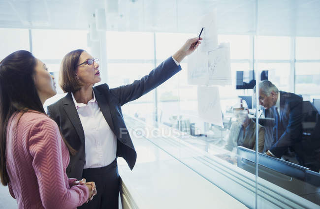 Les femmes d'affaires discutent tableau dans le bureau — Photo de stock