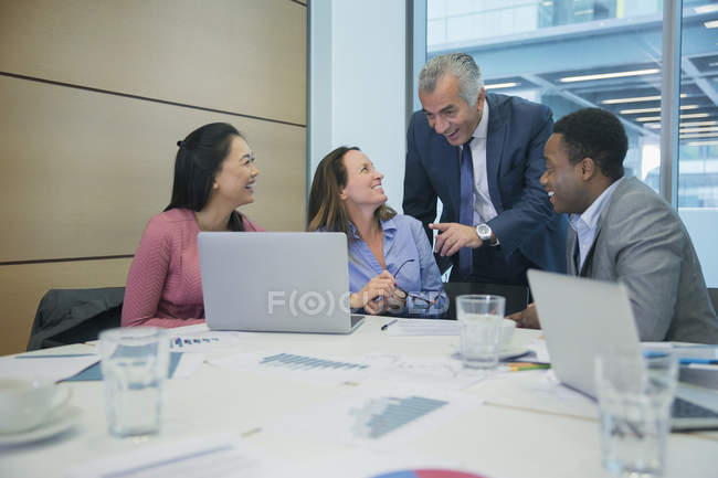 Lächelnde Geschäftsleute mit Laptop im Konferenzraum — Stockfoto