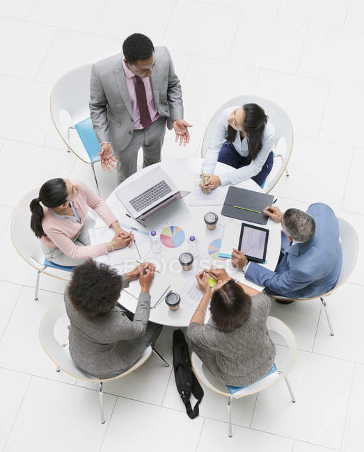 High angle view businessman leading meeting at round table — Stock Photo