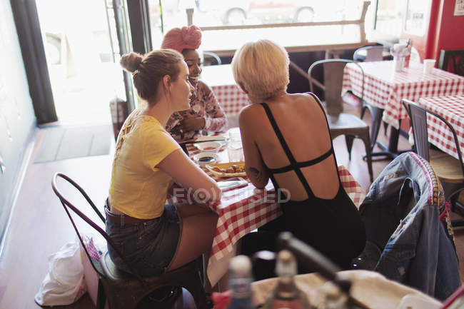 Jóvenes amigas cenando en restaurante - foto de stock