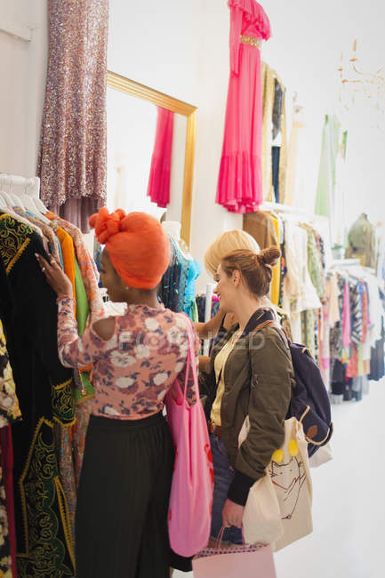 Giovani donne amiche shopping nel negozio di abbigliamento — Foto stock