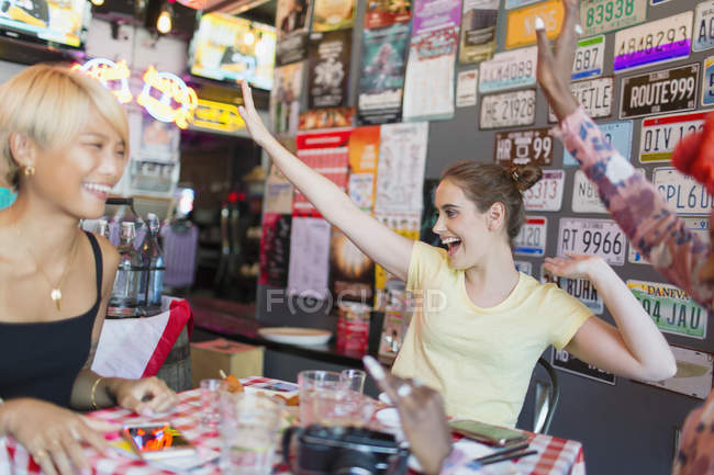 Enthousiaste jeunes femmes amis acclamant dans le bar — Photo de stock