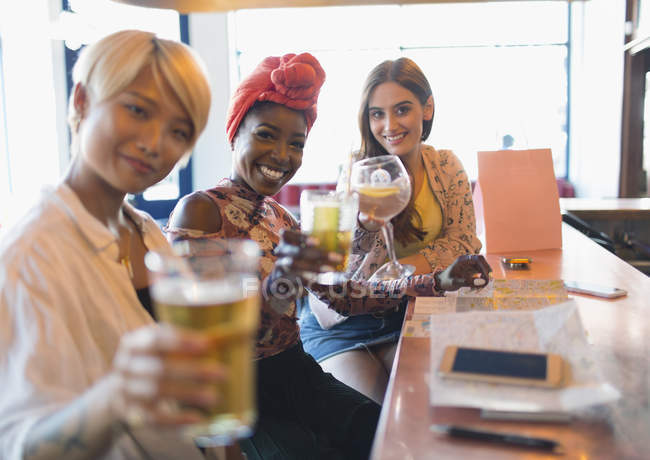 Портрет улыбающейся, уверенной в себе молодой женщины друзья тост коктейли в баре — стоковое фото