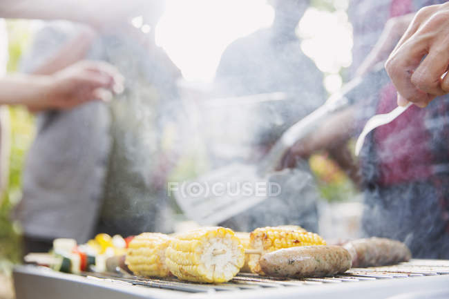 Corncobs, saucisses et brochettes de légumes cuisson sur barbecue — Photo de stock