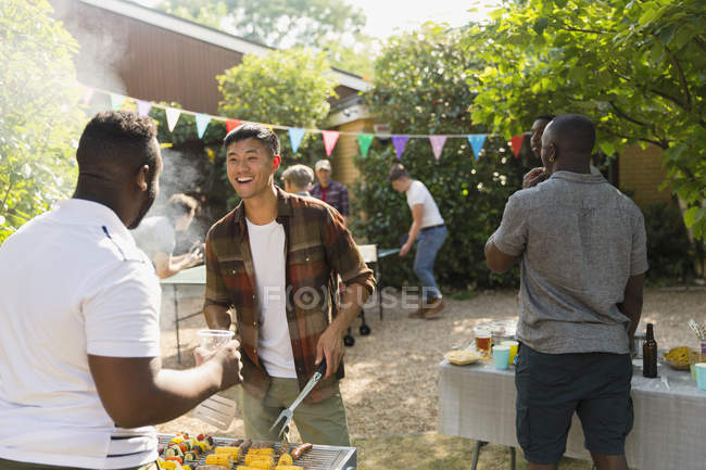 Male friends enjoying backyard summer barbecue — Stock Photo