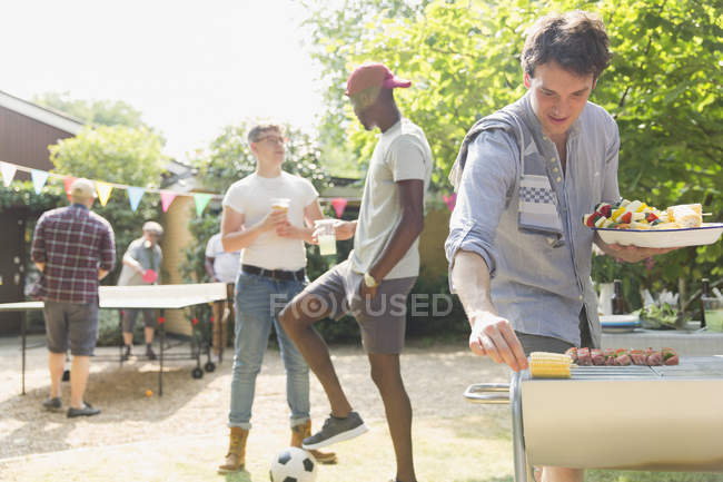 Male friends enjoying summer backyard barbecue — Stock Photo