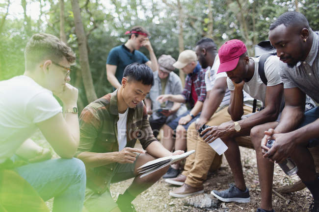 Mens group with map preparing for hike in woods — Stock Photo