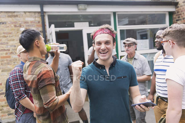 Portrait enthusiastic man with mens group in parking lot — Stock Photo