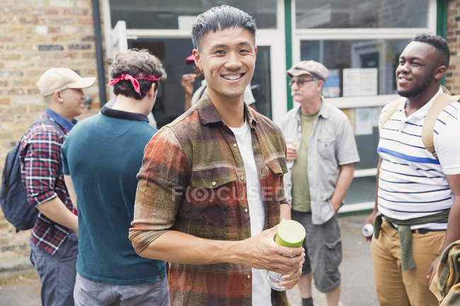 Portrait smiling man with mens group in parking lot — Stock Photo