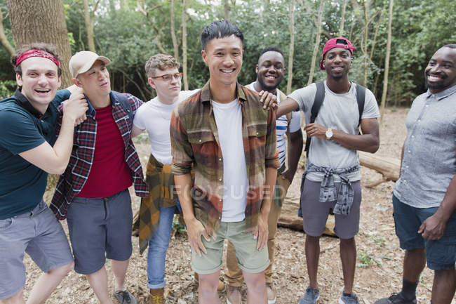 Portrait happy, carefree mens group hiking in woods — Stock Photo
