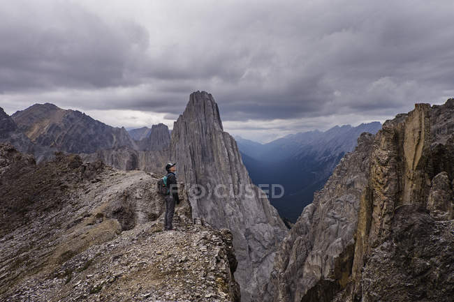 Senderista en craggy, remote mountaintop, Banff, Alberta, Canadá - foto de stock