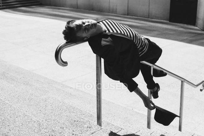 Retrato jovem inclinado sobre trilhos urbanos — Fotografia de Stock