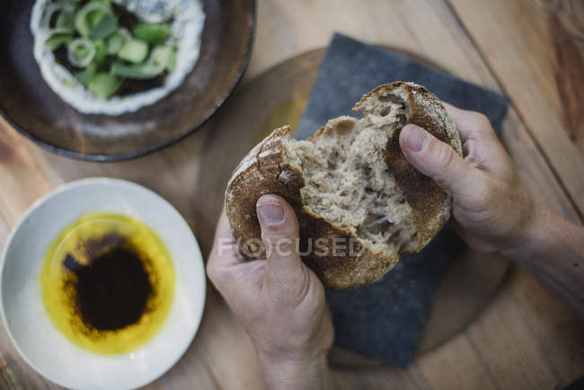 Personal perspective hands breaking bread — Stock Photo