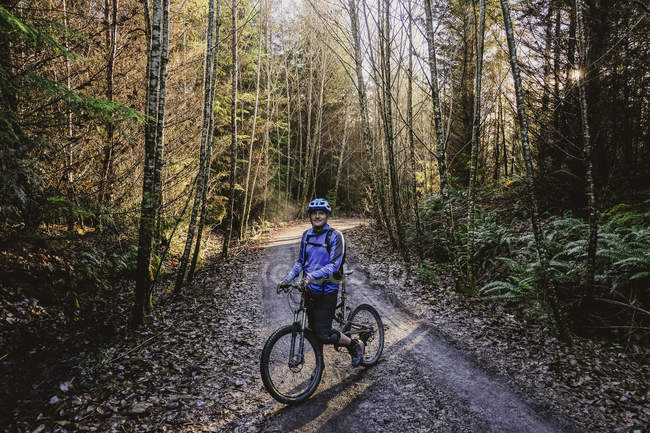 Retrato homem confiante mountain bike em florestas de outono, Squamish, BC, Canadá — Fotografia de Stock