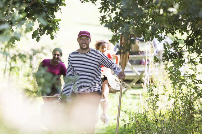 Family carrying canoe in woods — Stock Photo