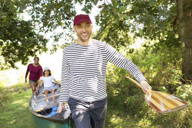 Famiglia che trasporta canoa nei boschi — Foto stock