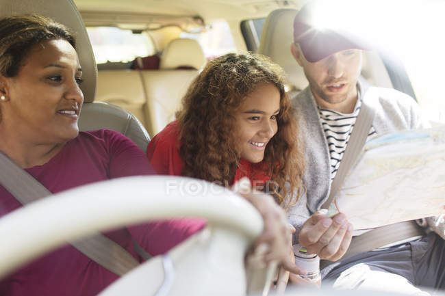Família com mapa andando de carro em viagem de carro — Fotografia de Stock