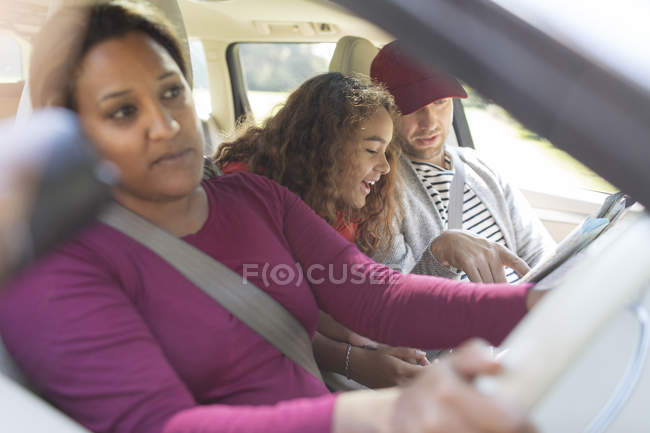Famille avec carte en voiture sur la route — Photo de stock