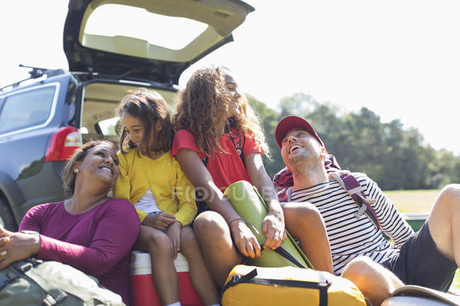 Счастливая семья с кемпинговым оборудованием на заднем сиденье автомобиля — стоковое фото