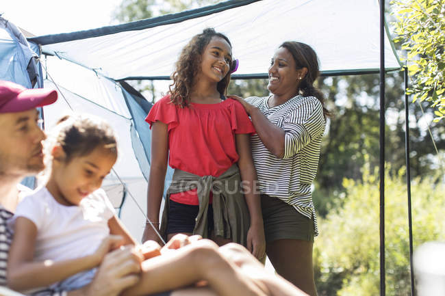 Affectionate mother brushing daughter hair at campsite — Stock Photo
