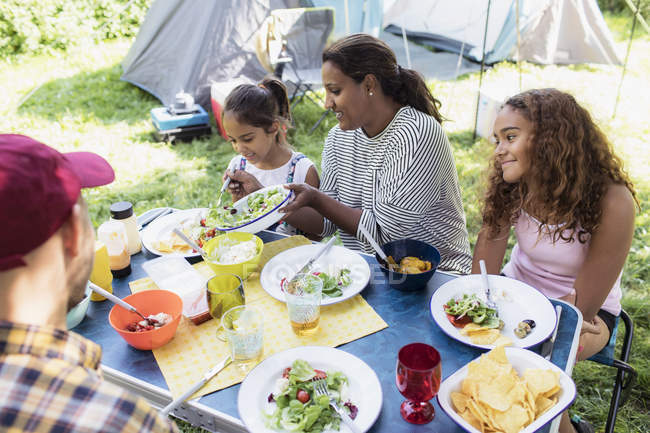 Family enjoying lunch at campsite table — Stock Photo