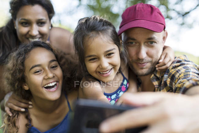 Счастливая семья делает селфи с телефоном — стоковое фото
