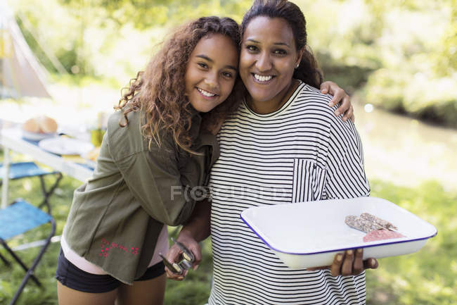 Portrait affectionate mother and daughter barbecuing at campsite — Stock Photo