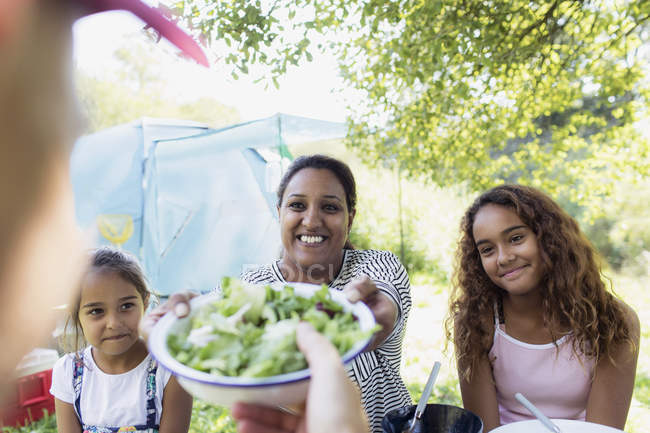 Happy family enjoying salad lunch at campsite — Stock Photo