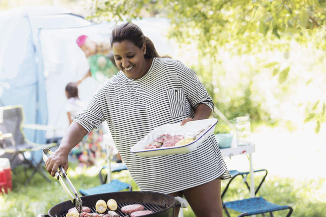 Barbecues femme au camping — Photo de stock
