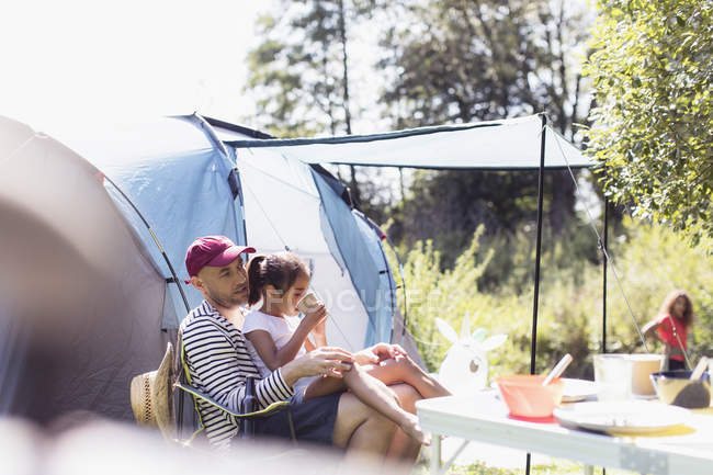Father and daughter relaxing at campsite — Stock Photo